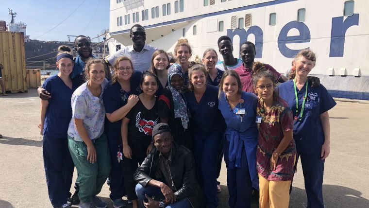 Gabrielle Dent with colleagues standing in front of the African Mercy ship.